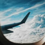 Eventi nel mondo, viaggiare in aereo permette di non perderseli. Nell'immagine: la vista fuori dal finestrino di un aereo, con un pezzo del velivolo e delle nubi