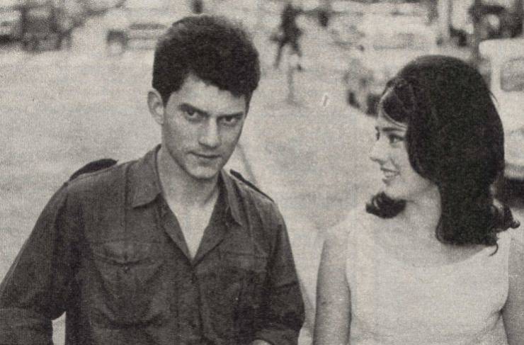 una foto in bianco e nero di Luigi Tenco e Donatella Turri sul set del film "La cuccagna"