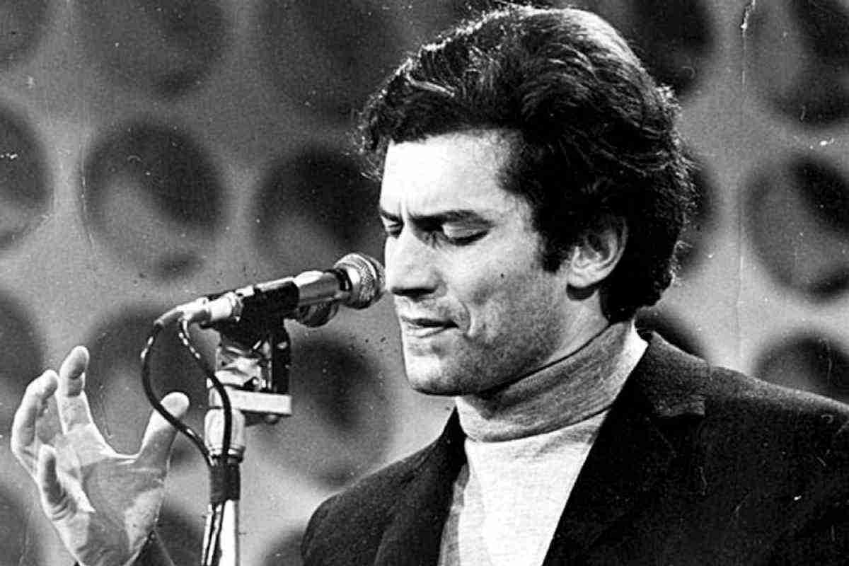 una foto in bianco e nero di Luigi Tenco che canta a Sanremo nel 1967.