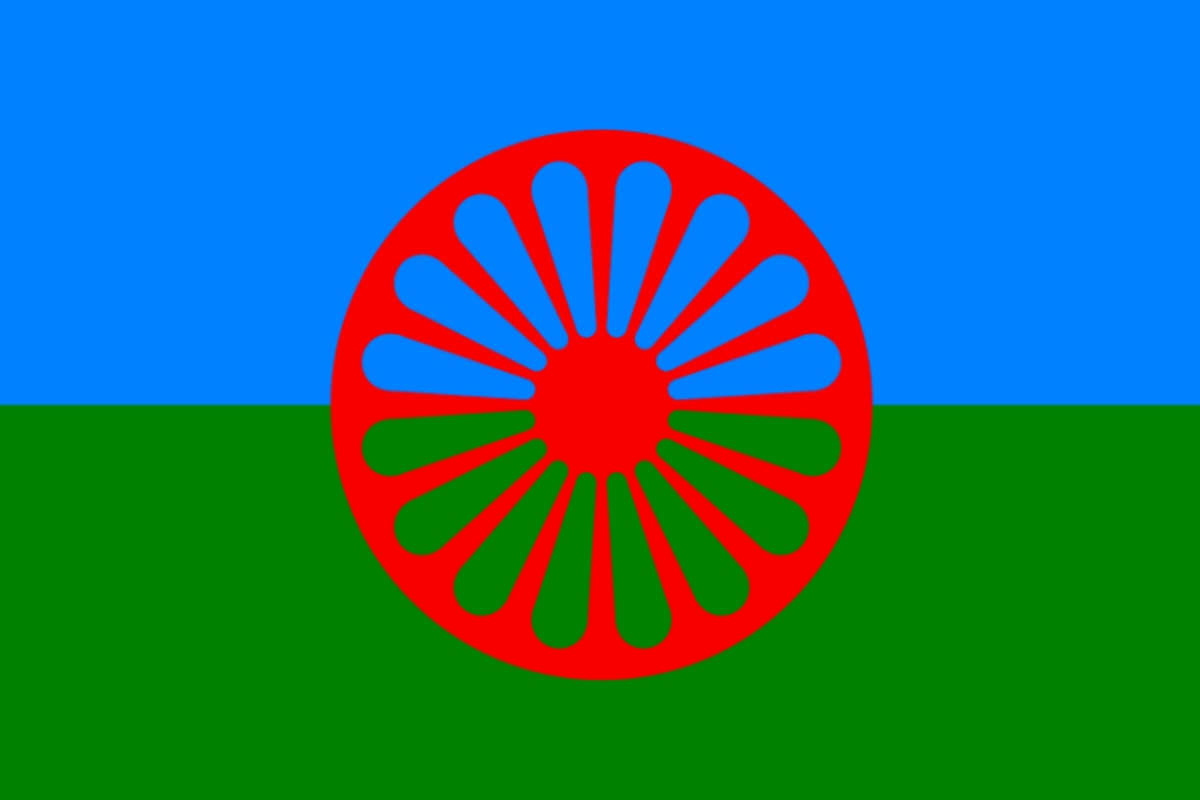 bandiera di rom, sinti e camminanti, con fascia blu superiore, fascia verde inferiore sormontate da una ruota rossa a 16 raggi